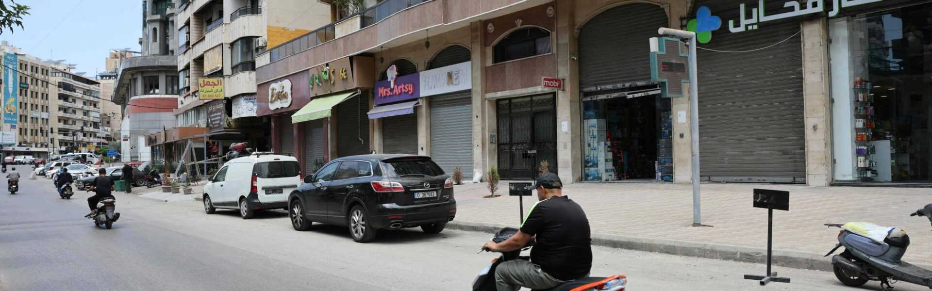 أحد شوارع الضاحية الجنوبية لبيروت حيث أقفلت المحالّ أبوابها وغادرها السكان على أثر التهديد الإسرائيلي بقصفها الاثنين (أ.ف.ب)