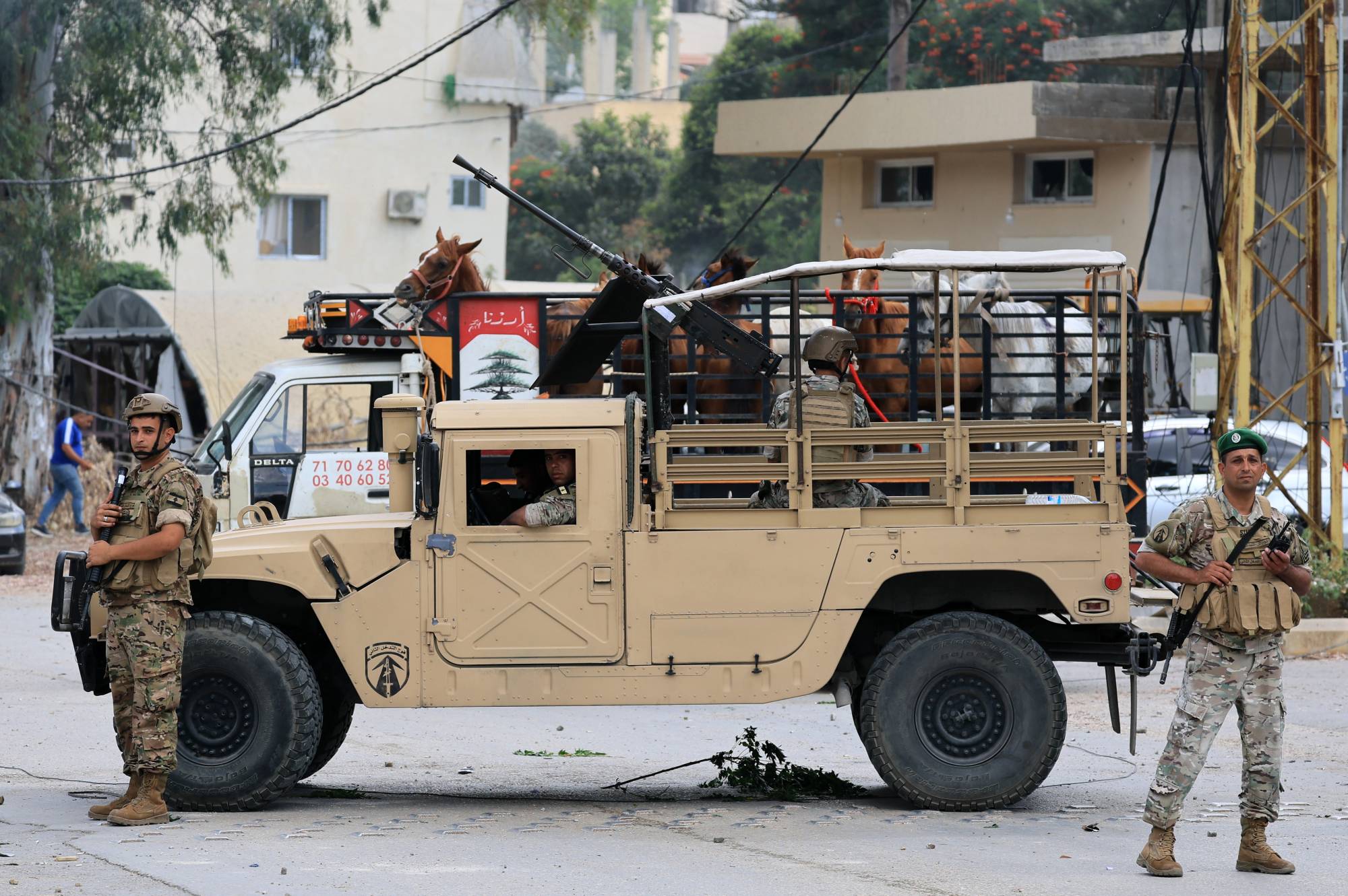 قوة من الجيش اللبناني تنتشر على مدخل بلدة زوطر الغربية المدرجة ضمن المنطقة التجريبية في جنوب لبنان وتنتشر القوات الإسرائيلية على أطرافها (إ.ب.أ)